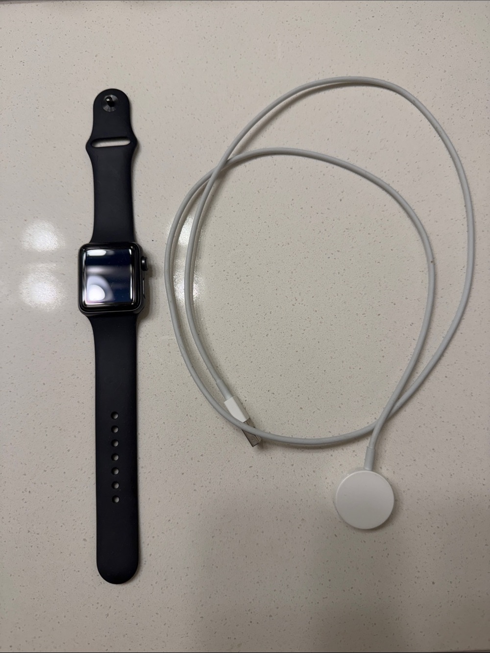 Apple Smartwatch with Black Sport Band and White Charger Cable